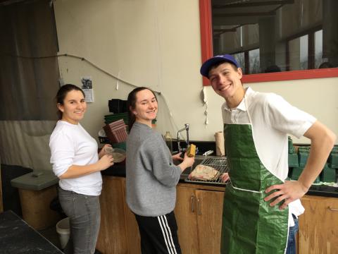 3 students cleaning up the greenhouse