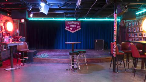 Nevarez & Tevere, The Lonesome Rose, 2021. Archival Pigment Print on Hahnemühle Photo Rag Baryta, 17 x 30" Alt Text: interior view of an empty stage in a bar.