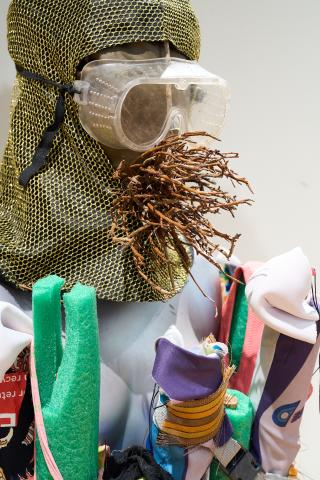 head form and twigs with goggles and textured fabric 