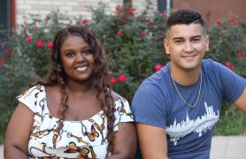 Two Students Seated on a Bench on Alumni Walk