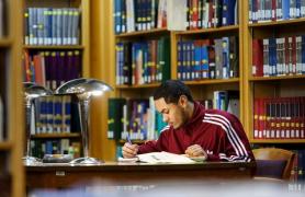 male student seated in library