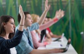 students raising hand in classroom