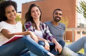 group of students sitting on ground on campus