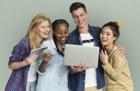 group of students looking at  laptop