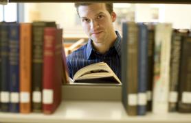 Faculty member reading a book