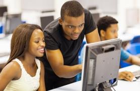 Students Helping And Working On Computer
