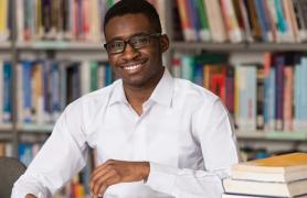Student Sitting In Library With Books