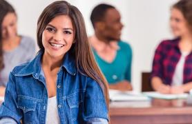 Students Seated At Desk Working In Class