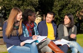 Students Outside Reading From Textbook