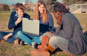 Students Outside Looking at Computer